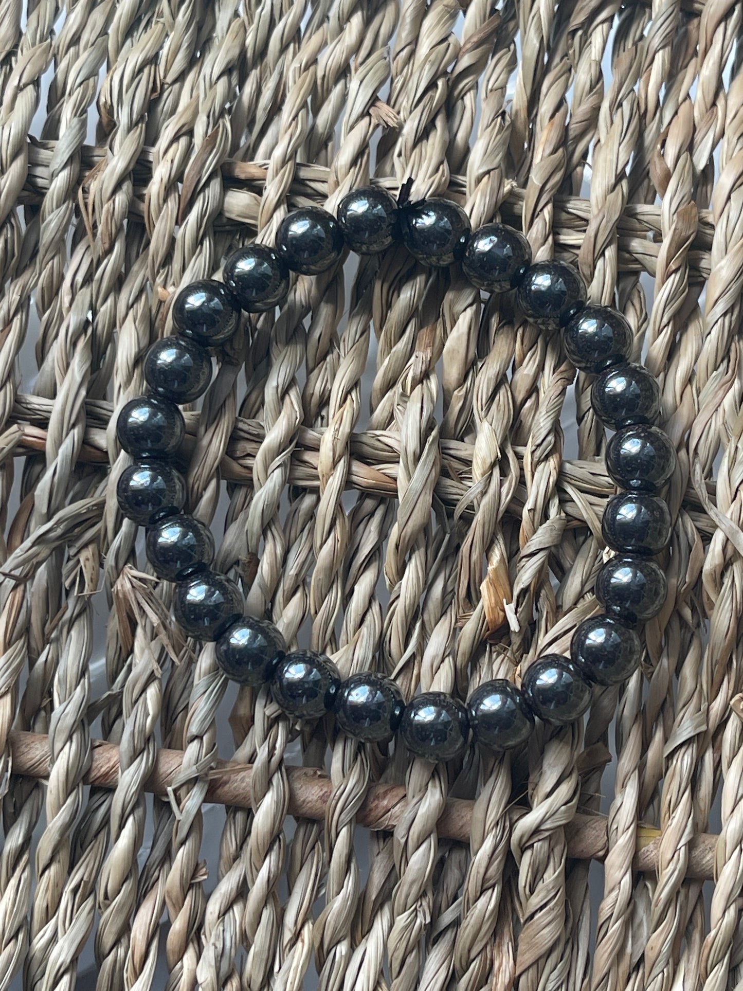 Black beaded bracelet on a woven surface Hematite Bracelet Florida at Pure Energy Crystals