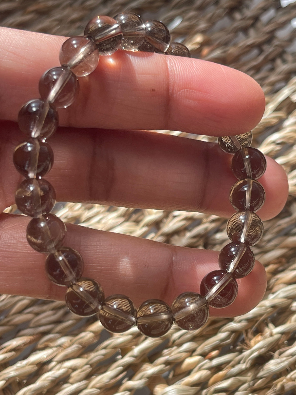 Smoky Quartz Beaded bracelet on a hand with a textured background
