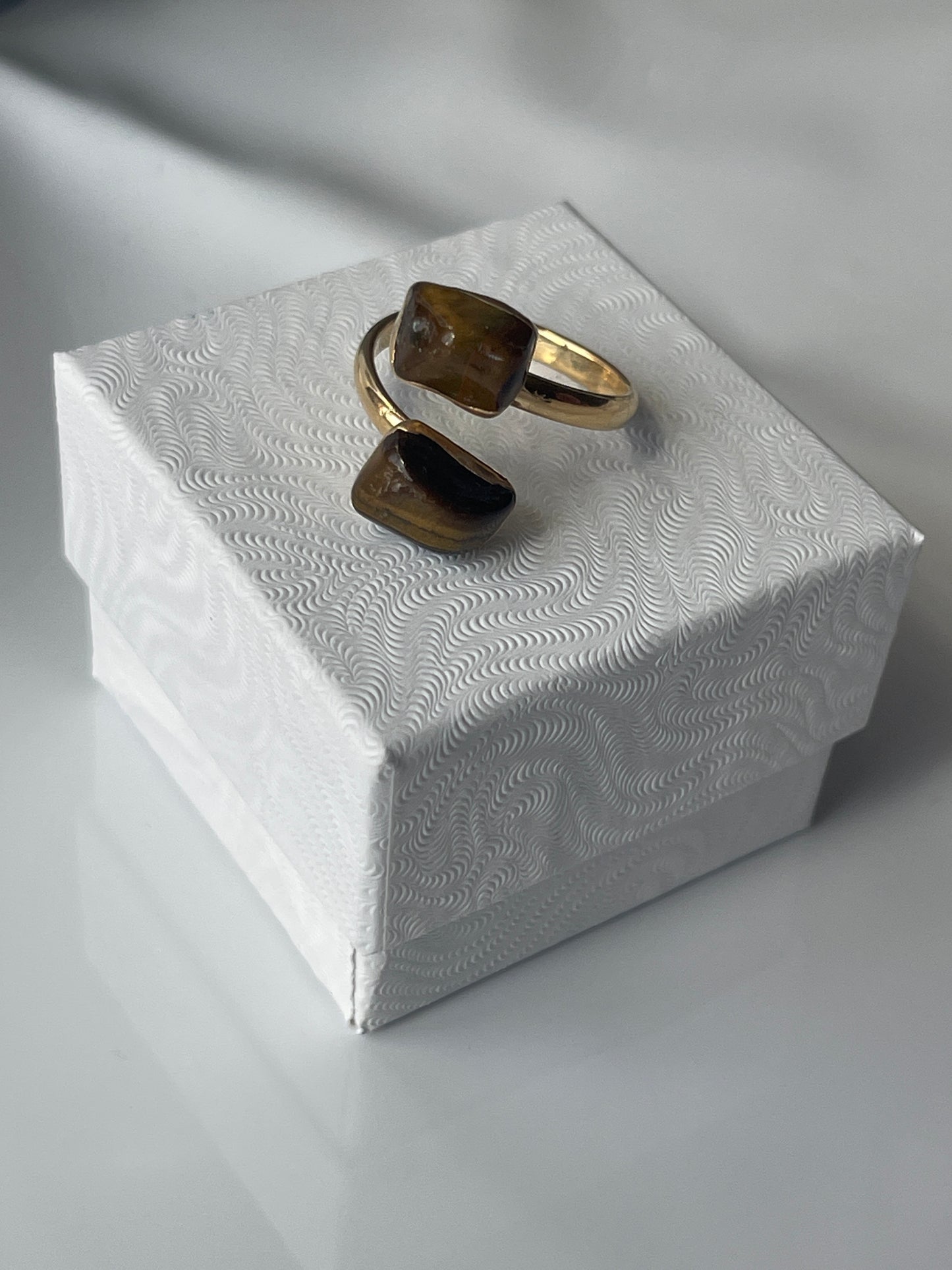 Tigers eye gold plated Ring on a textured white jewelry box in Florida