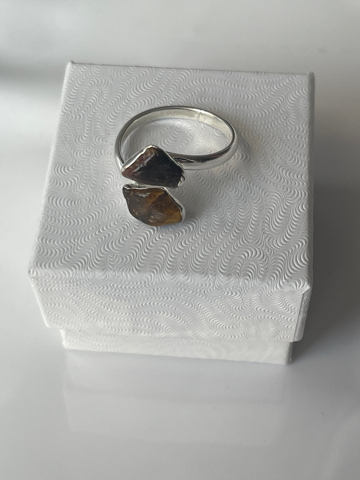 Tigers eye silver plated ring on a textured white jewelry box in Florida