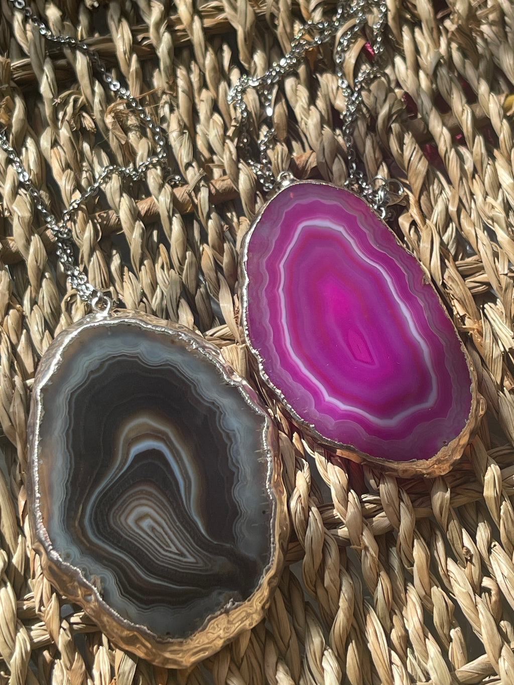 Two agate slices with vibrant purple and brown patterns on a woven surface.