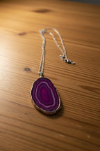 Necklace with a purple agate pendant on a light gray background