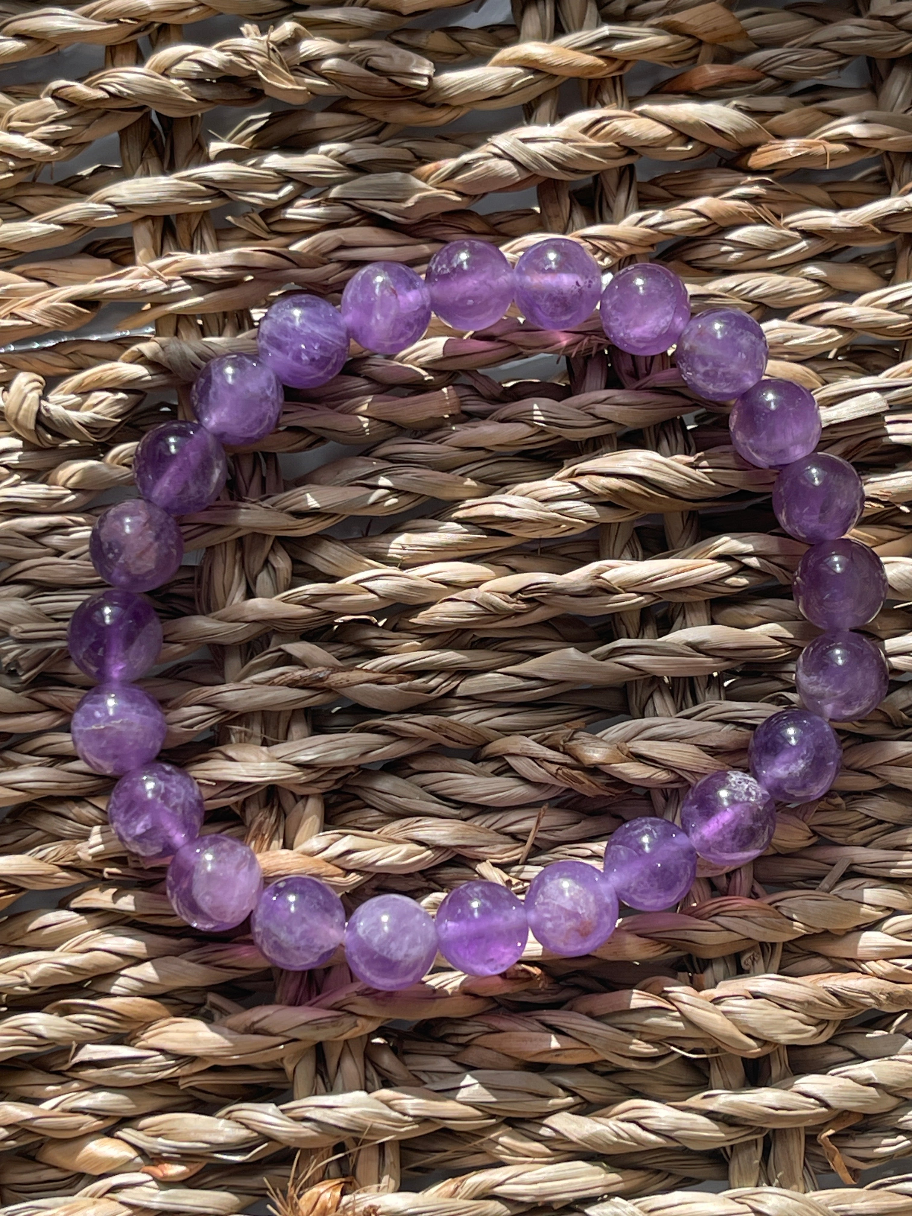 Purple beaded bracelet on a woven surface