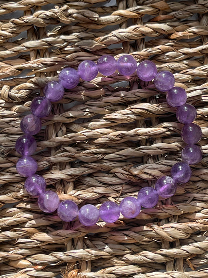 Purple beaded bracelet on a woven surface