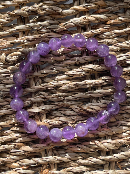 Purple beaded bracelet on a woven surface