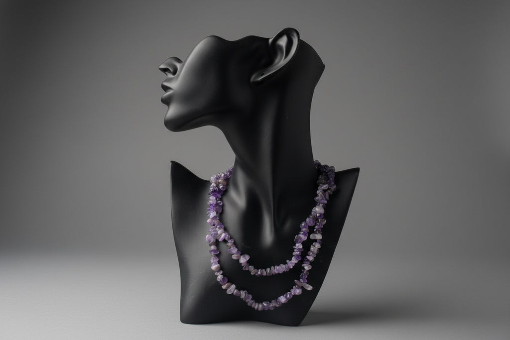 Black mannequin with a purple beaded Amethyst Chip Necklace on a textured surface.