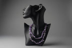 Black mannequin with a purple beaded Amethyst Chip Necklace on a textured surface.