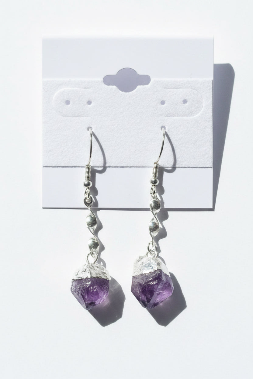 Amethyst Crystal Point Spiral Earrings on a gray card with a textured background