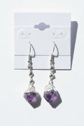 Amethyst Crystal Point Spiral Earrings on a gray card with a textured background