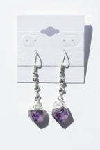 Amethyst Crystal Point Spiral Earrings on a gray card with a textured background