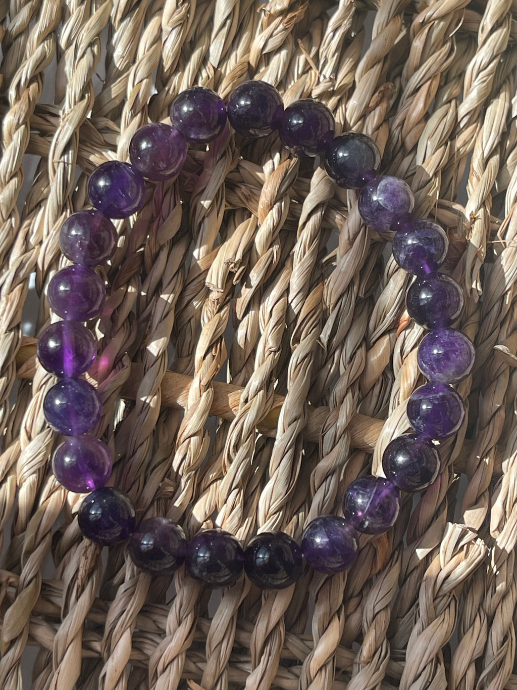 Purple beaded bracelet on a woven surface