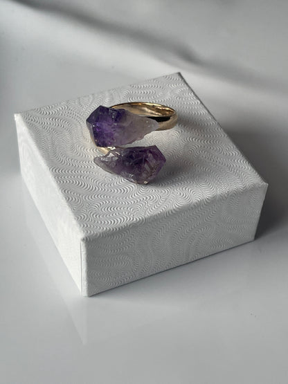 Amethyst ring on a textured white stand with soft lighting