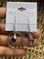 Amethyst Point Circle Earrings Silver plated hoop earrings with purple gemstones held against a white card.