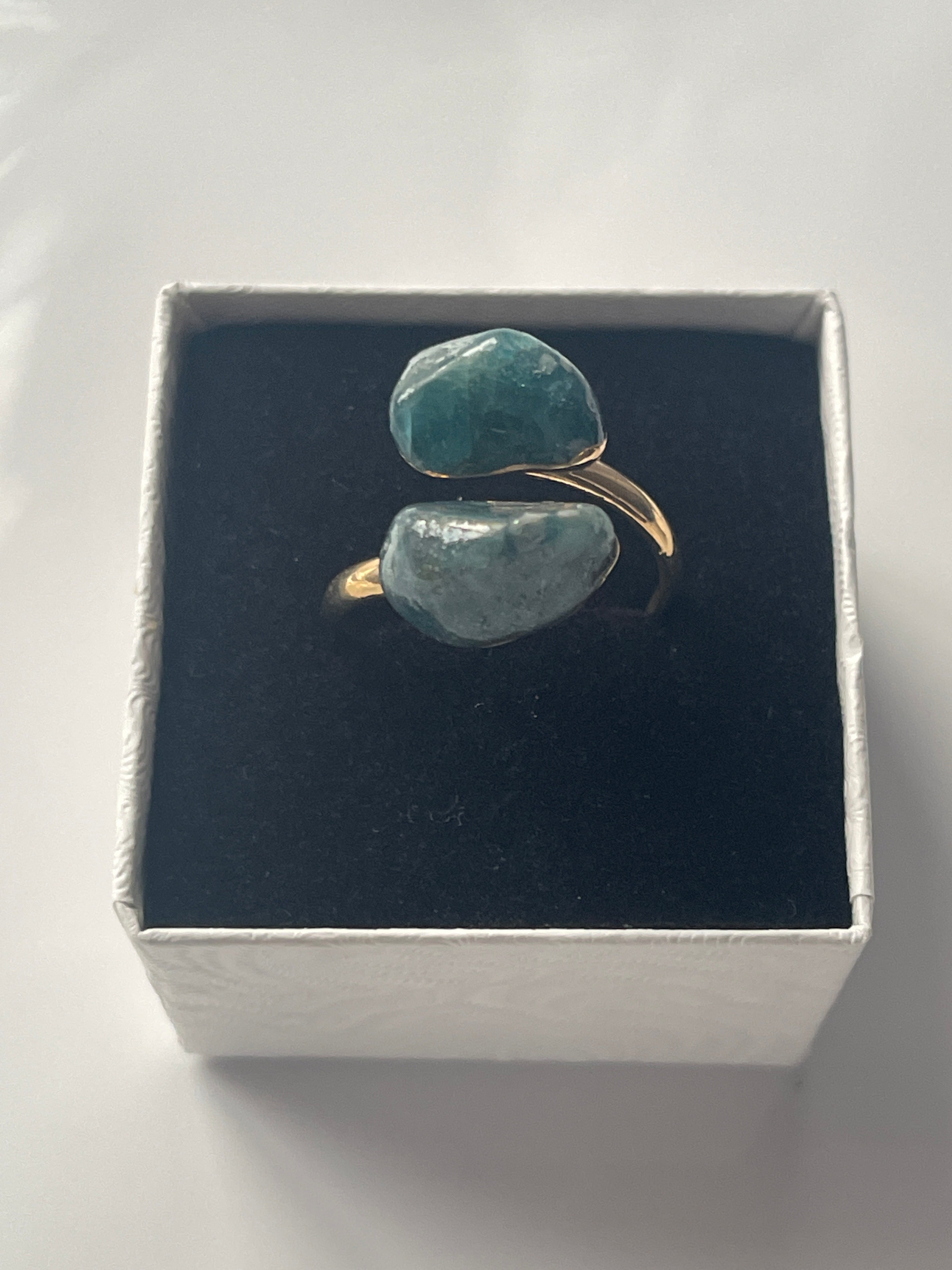 Gold plated Apatite adjustable ring inside a small white and black jewelry box 
