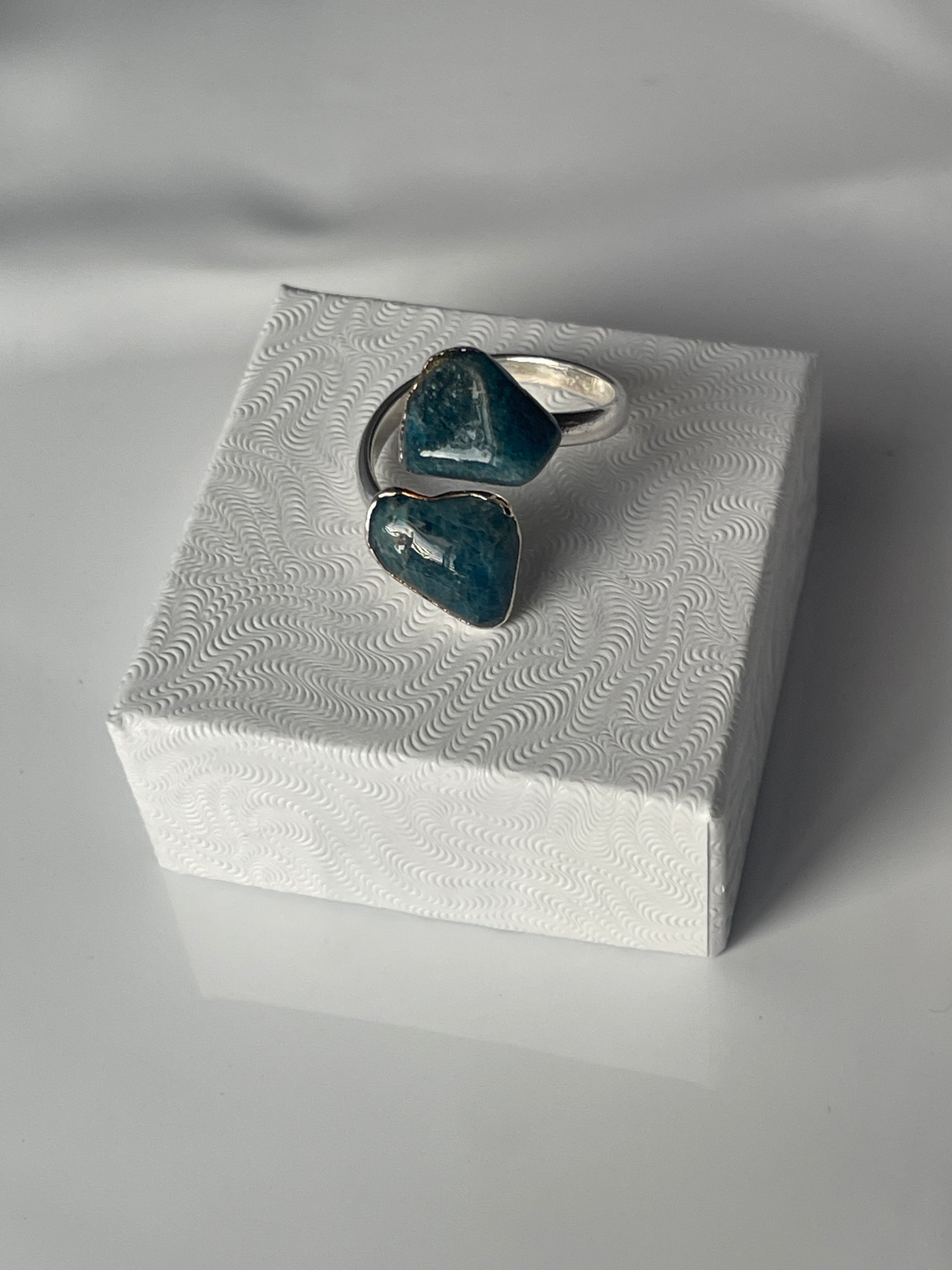 Apatite adjustable silver plated ring sitting on a white luxury jewelry box in Florida 