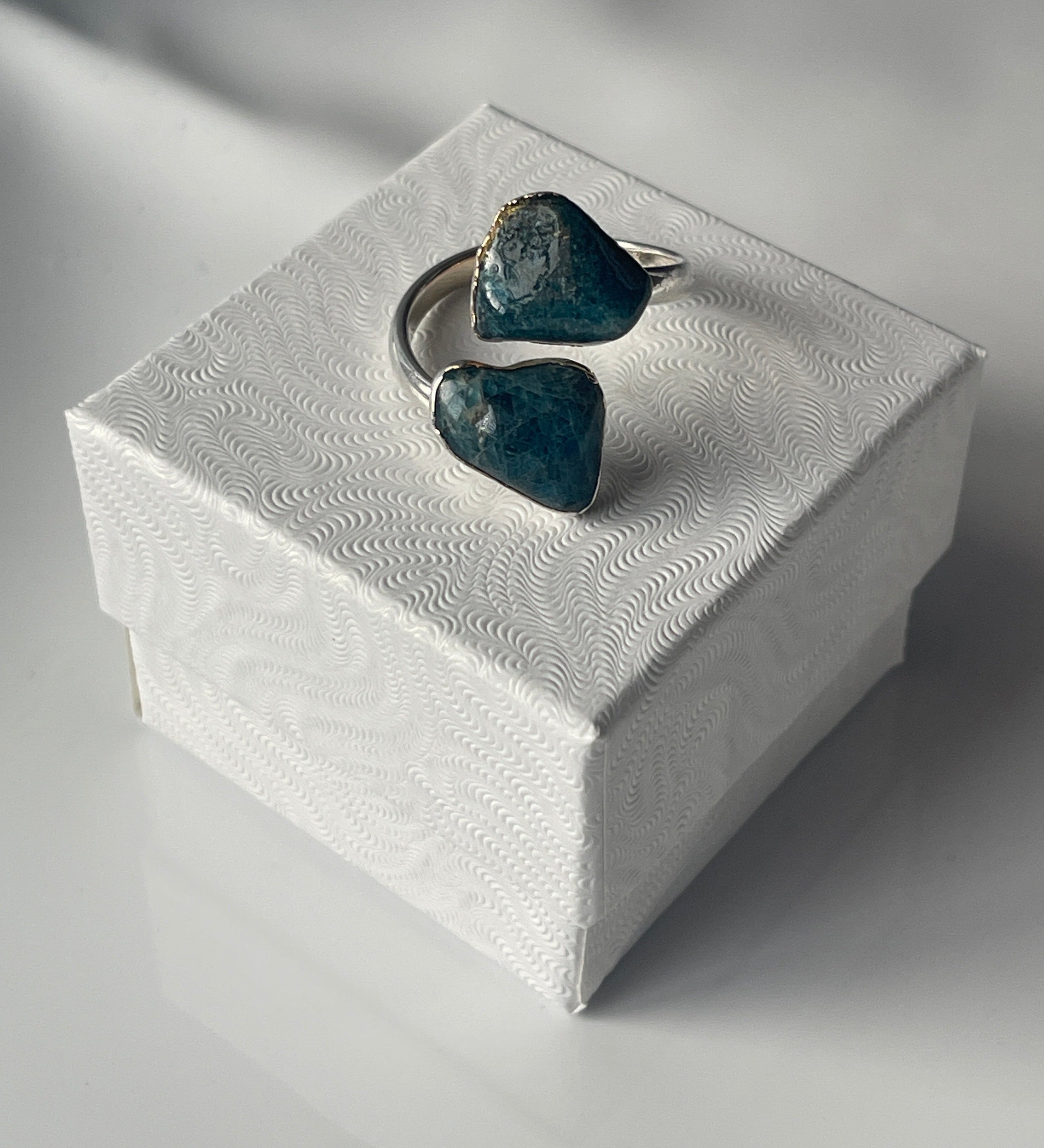 Apatite Ring, mineral specimen on a textured white platform with a blurred background