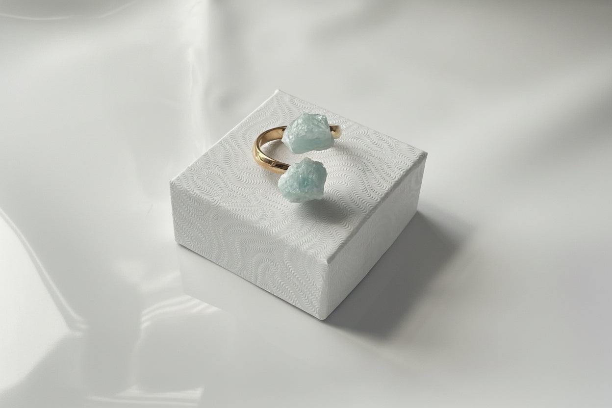 Aquamarine Adjustable Natural Gold Ring siting on a small white jewelry box top