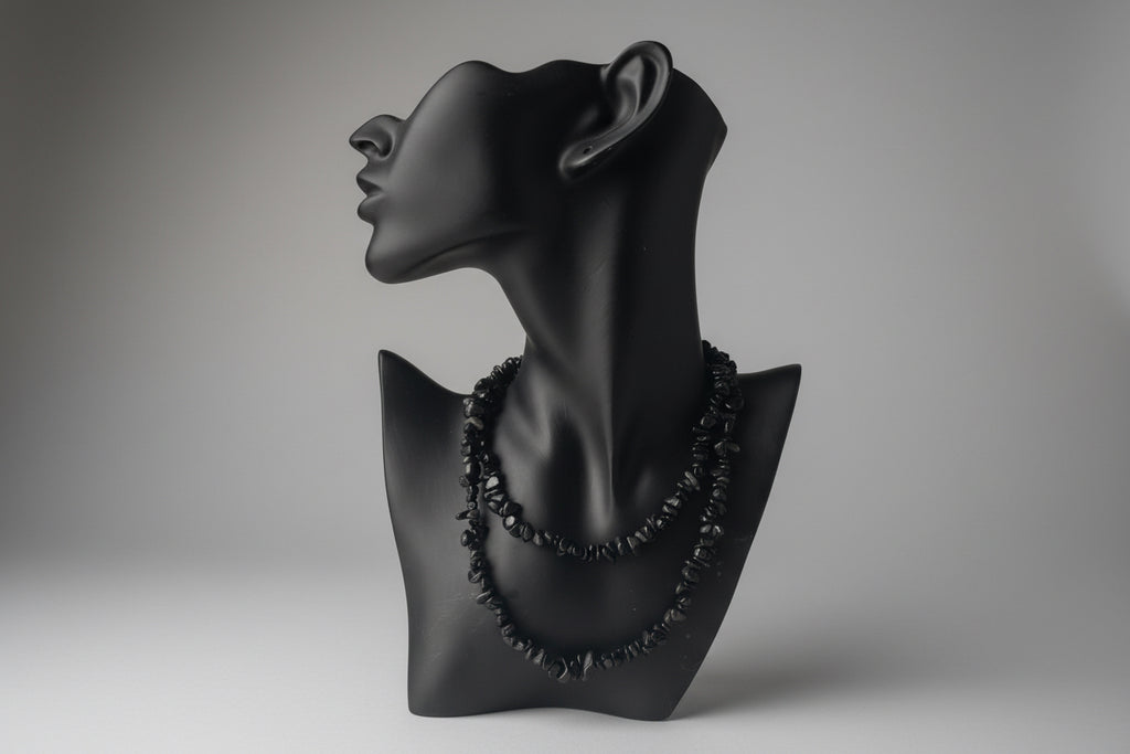 Black jewelry display with Black Obsidian Chip Necklace, blurred gray studio background