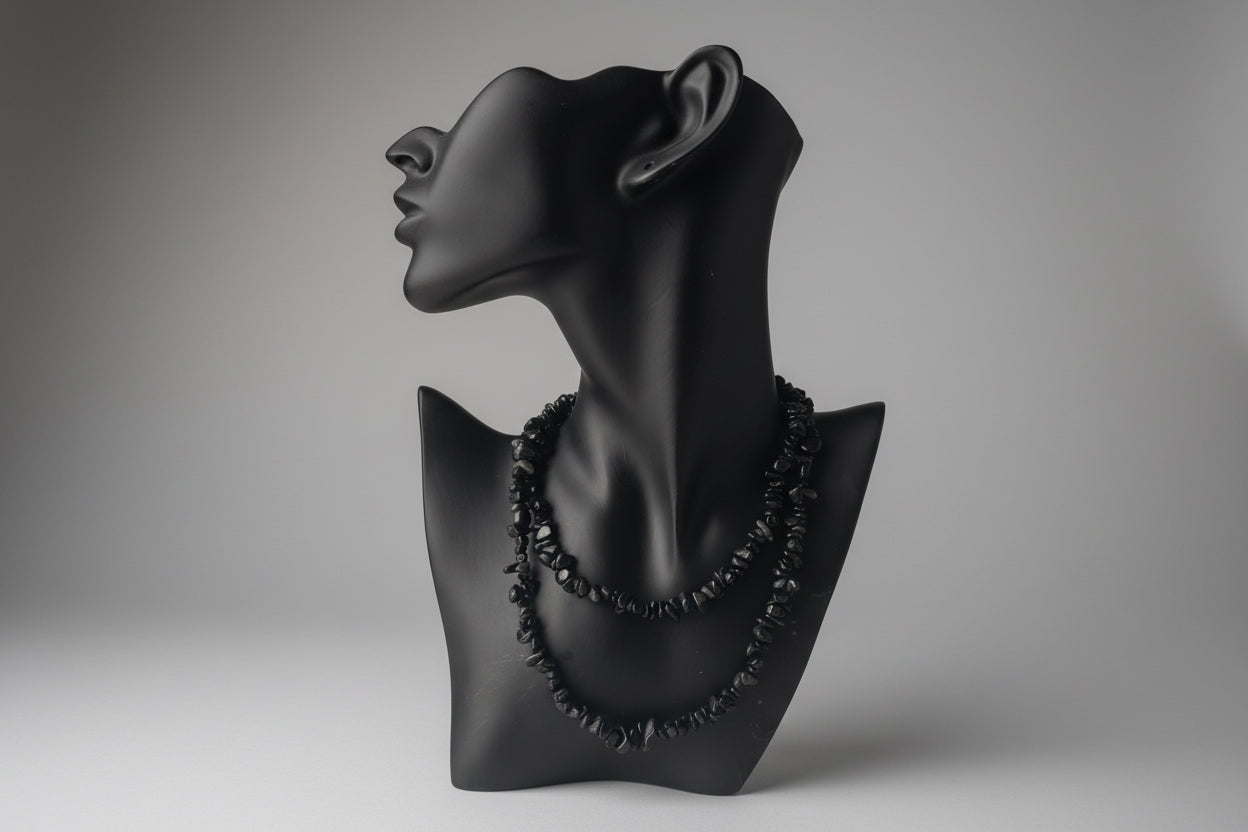 Black jewelry display with Black Obsidian Chip Necklace, blurred gray studio background