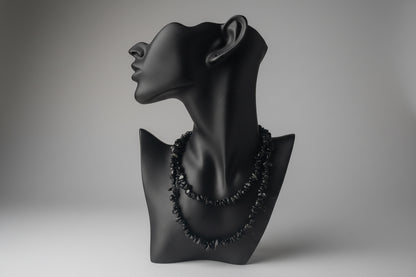 Black jewelry display with Black Obsidian Chip Necklace, blurred gray studio background