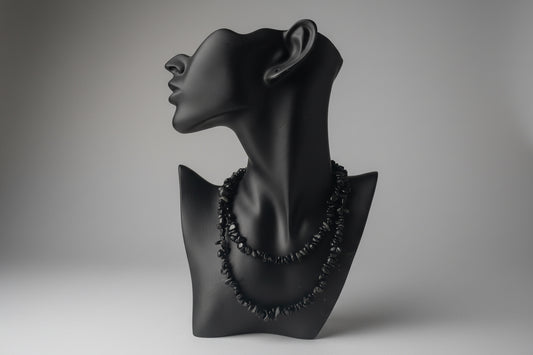Black jewelry display with Black Obsidian Chip Necklace, blurred gray studio background