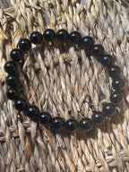 Black beaded bracelet on a woven mat