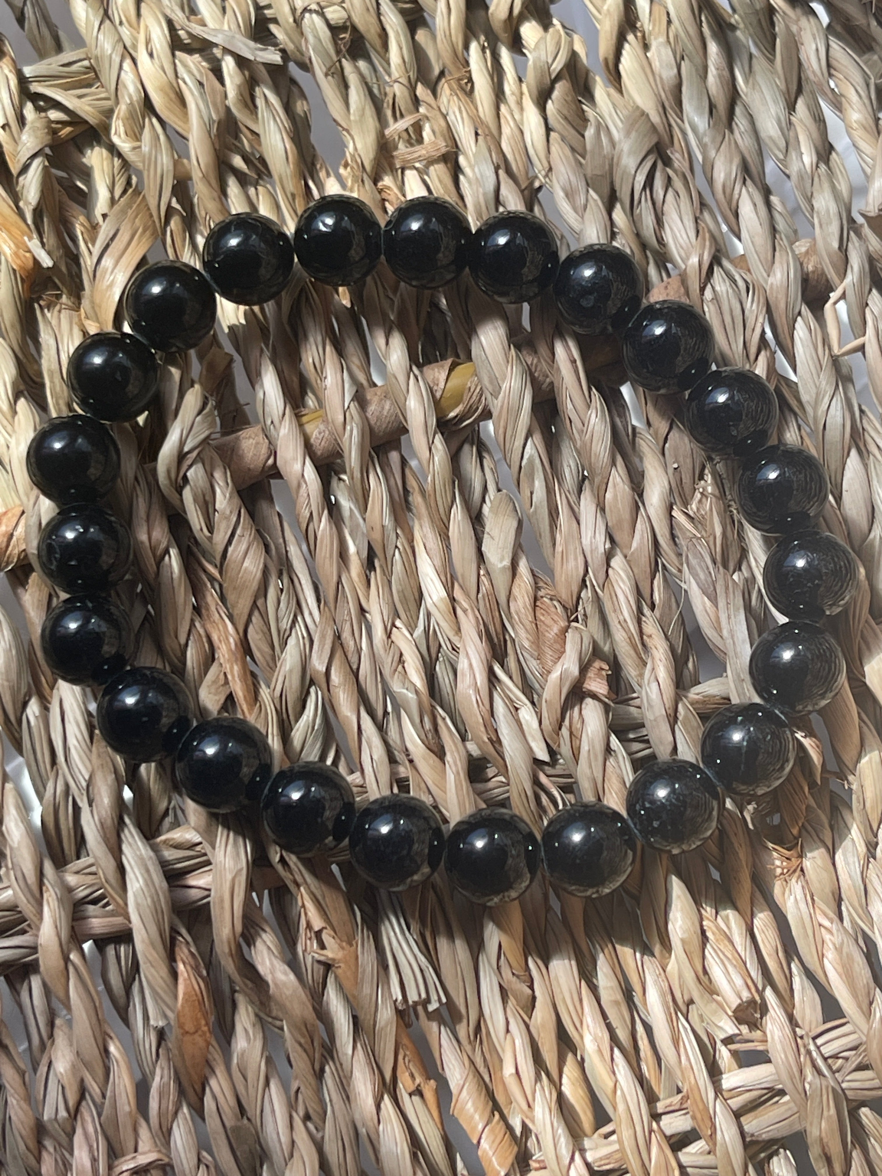 Black beaded bracelet on a woven mat