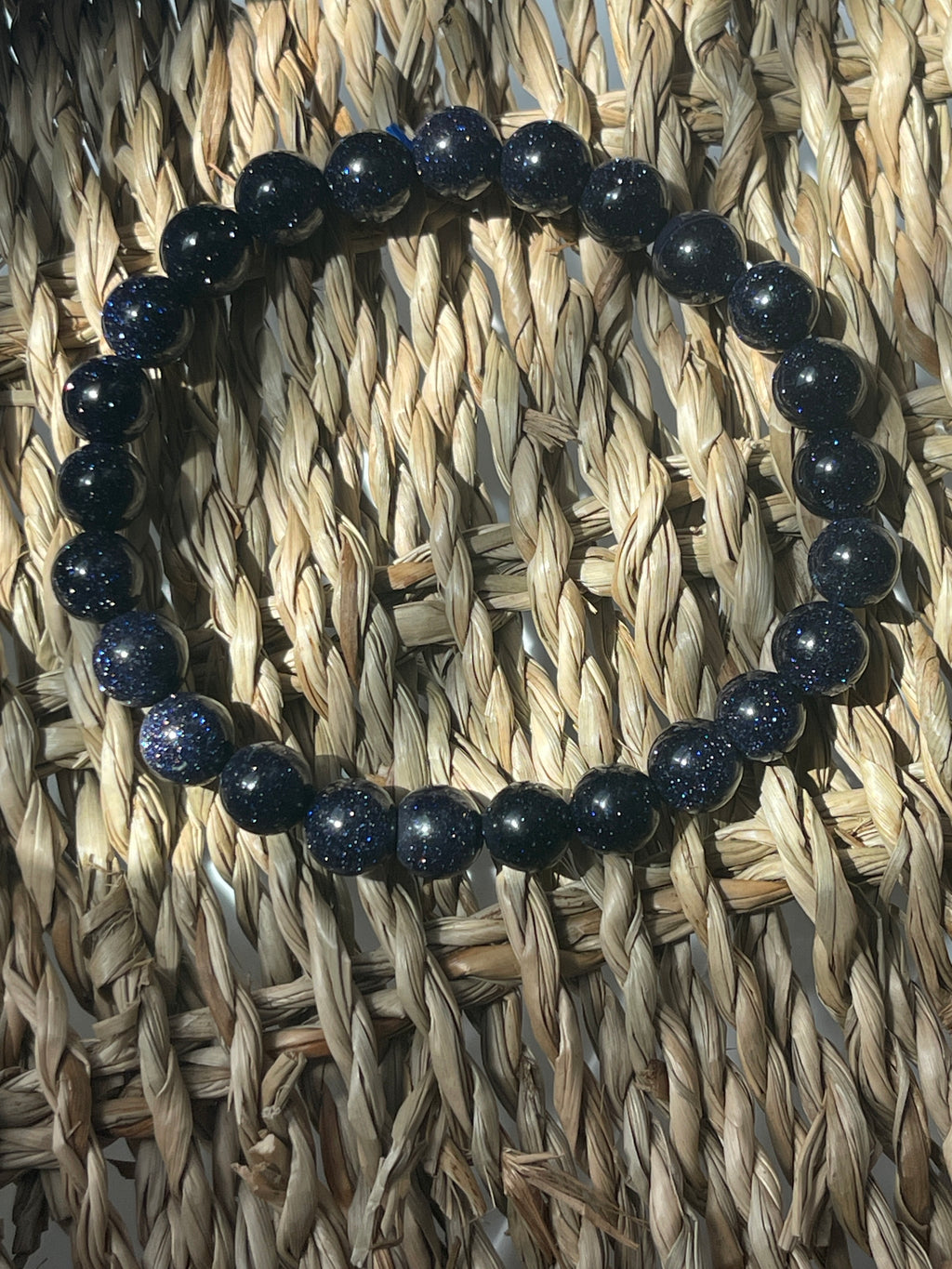 Blue beaded bracelet on a woven mat Blue Goldstone 8mm Bracelet at Pure Energy Crystals 