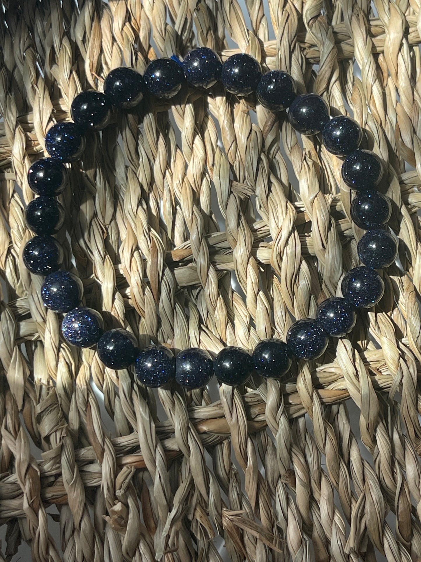 Blue beaded bracelet on a woven mat Blue Goldstone 8mm Bracelet at Pure Energy Crystals 