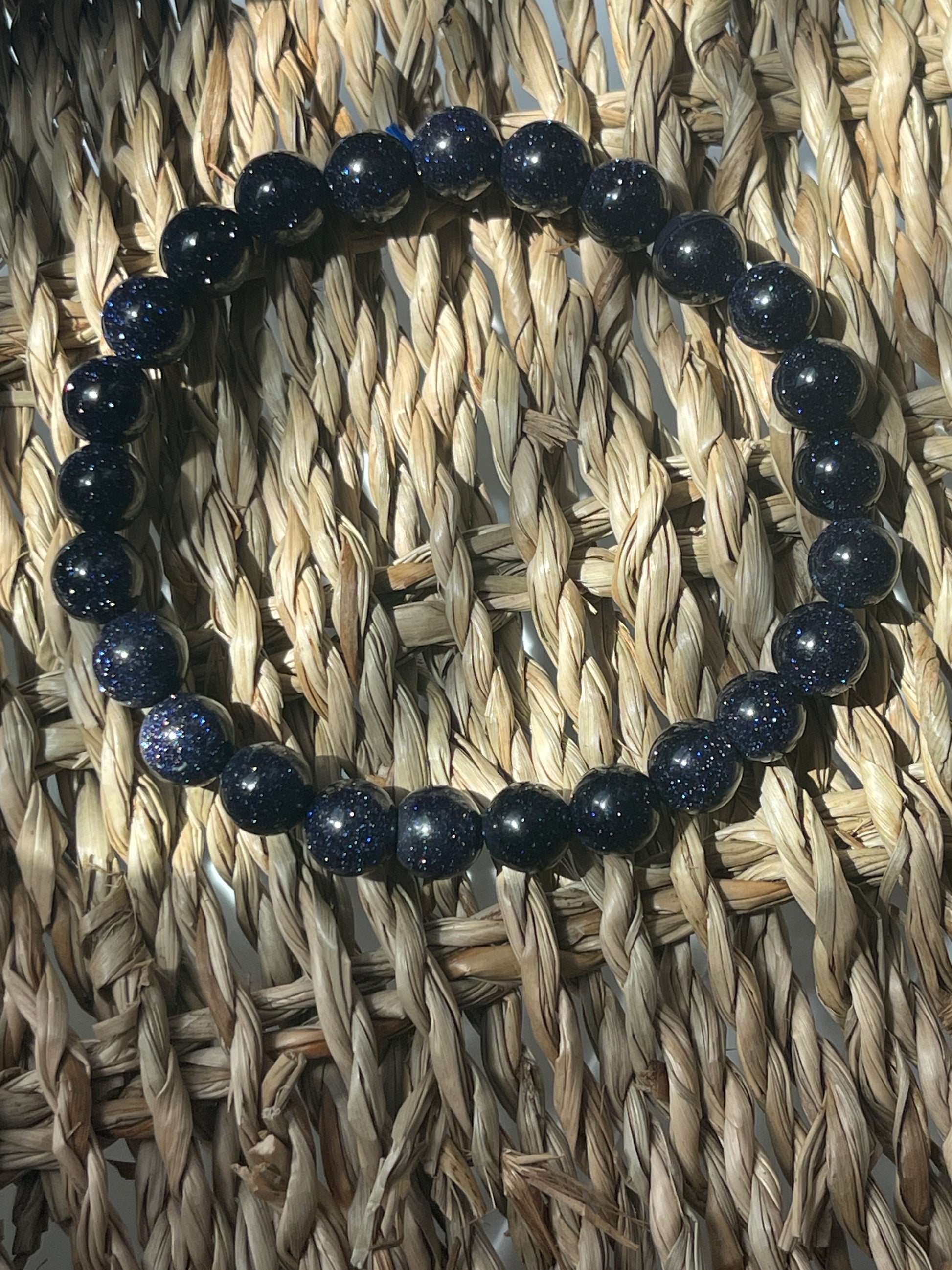 Blue beaded bracelet on a woven mat Blue Goldstone 8mm Bracelet at Pure Energy Crystals 