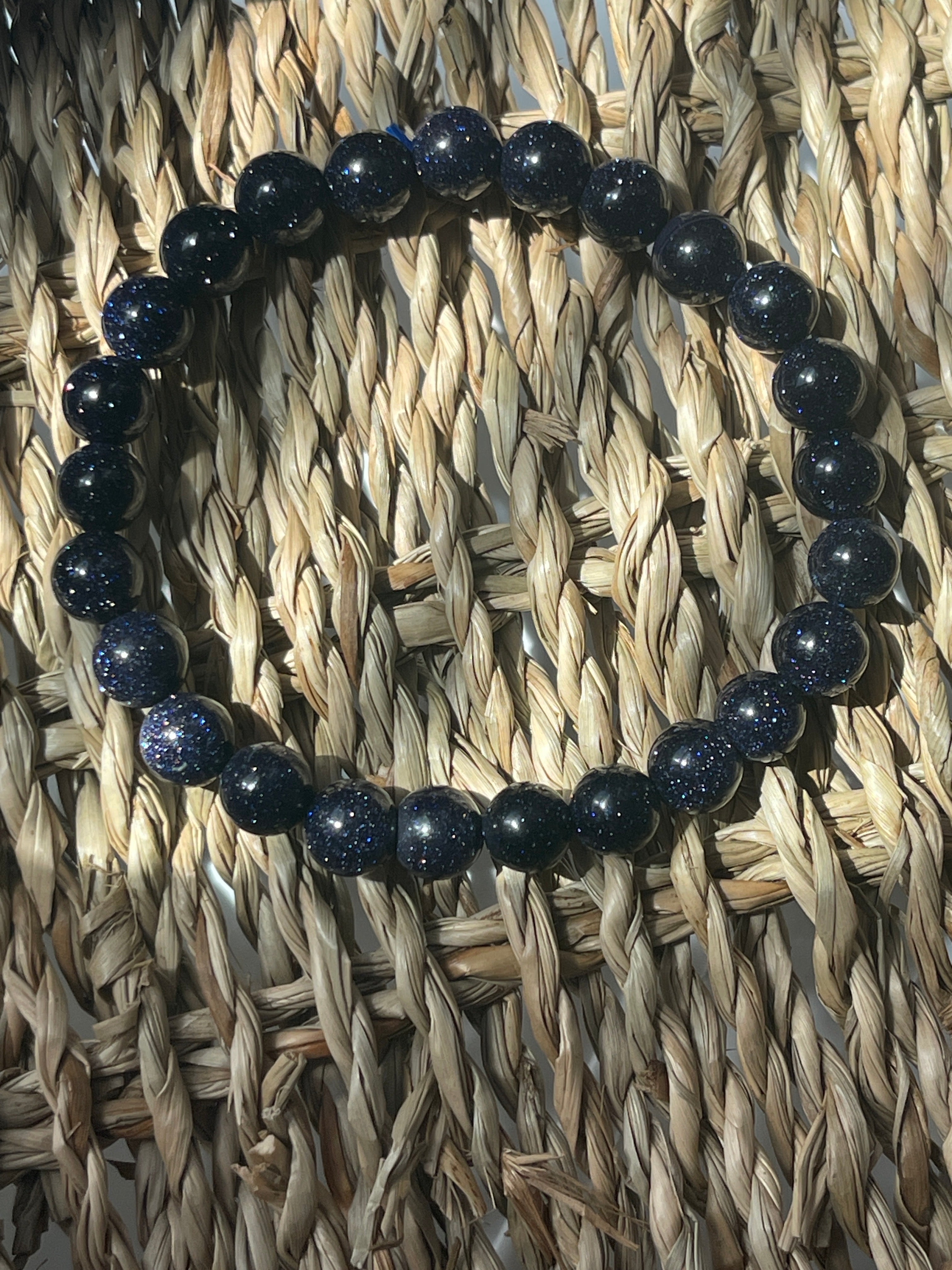 Blue beaded bracelet on a woven mat Blue Goldstone 8mm Bracelet at Pure Energy Crystals 
