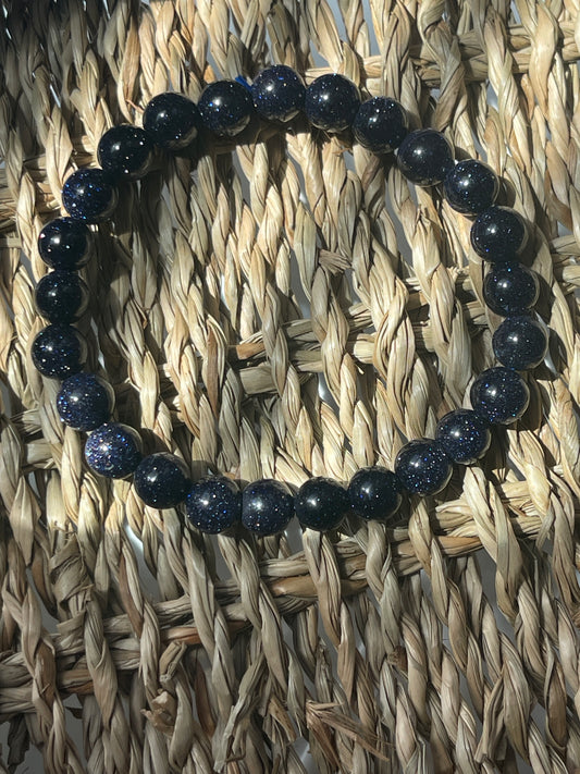 Blue beaded bracelet on a woven mat Blue Goldstone 8mm Bracelet at Pure Energy Crystals 