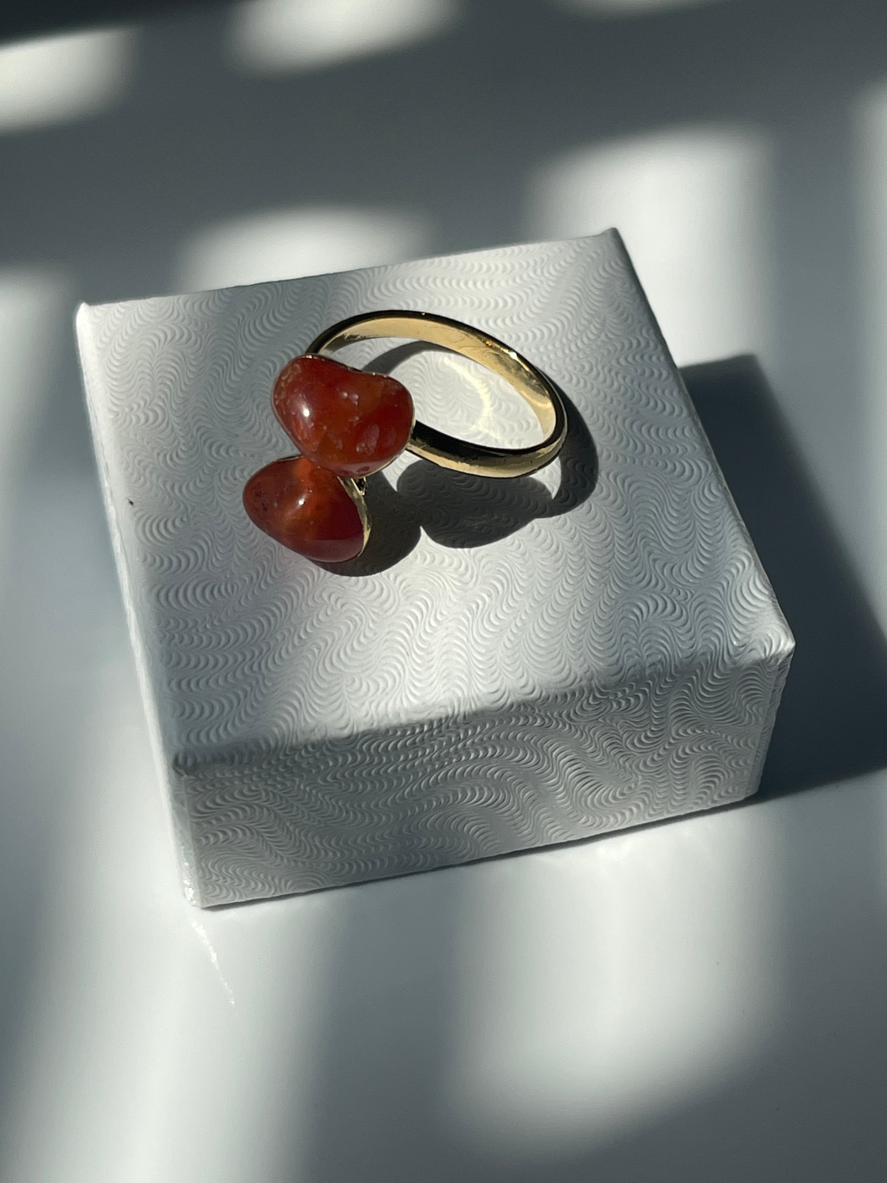 Carnelian Agate Gold plated ring with orange stones on a textured white jewelry box