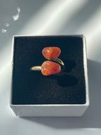 Carnelian Agate Ring with orange stones and gold band inside a black and white jewelry box