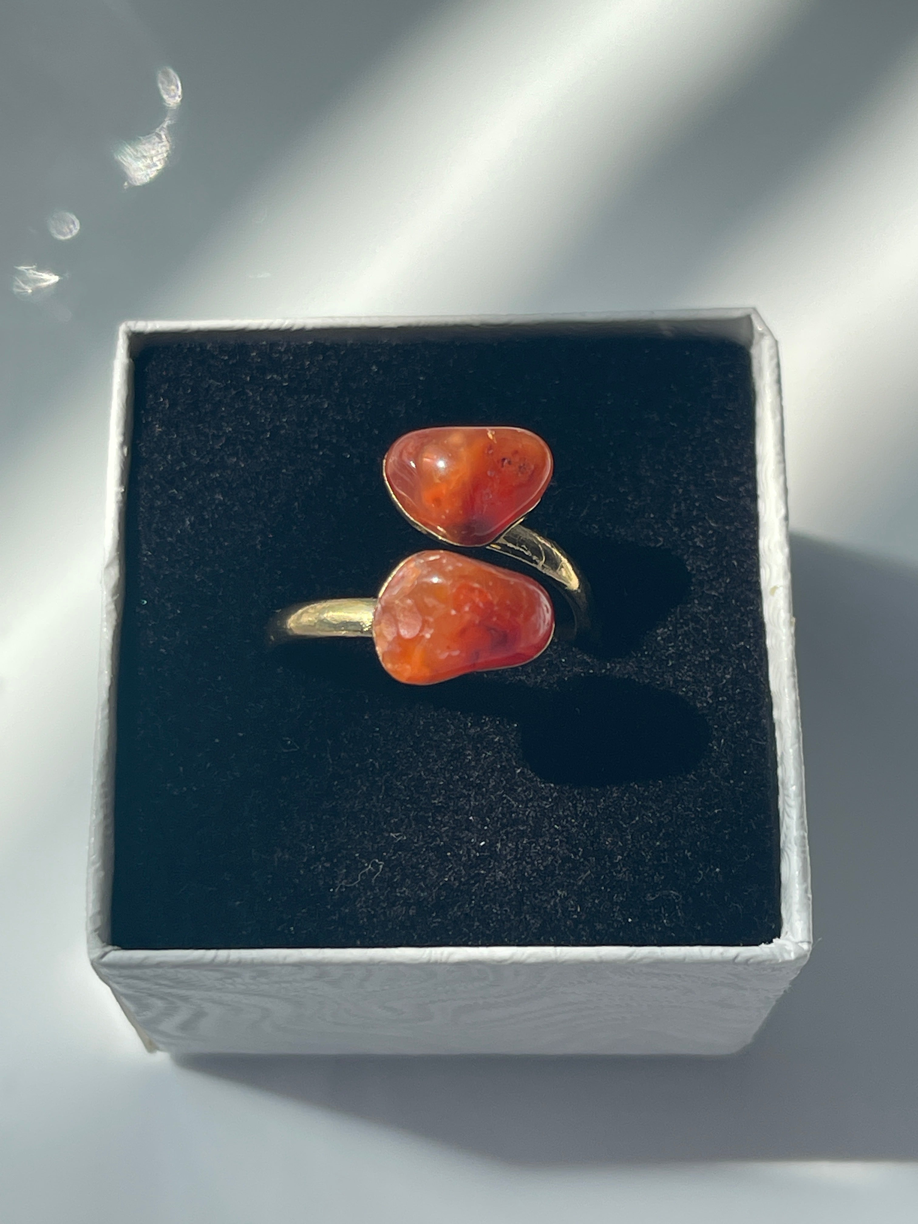 Carnelian Agate Ring with orange stones and gold band inside a black and white jewelry box