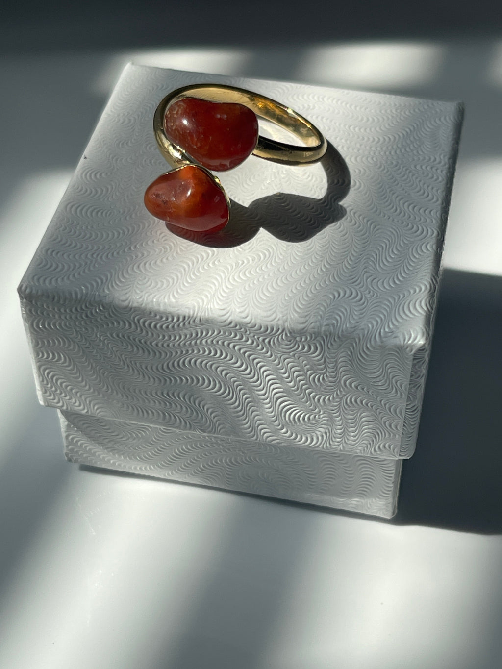 Carnelian Agate gold plated  ring with orange stones on a textured white jewelry box in Florida 