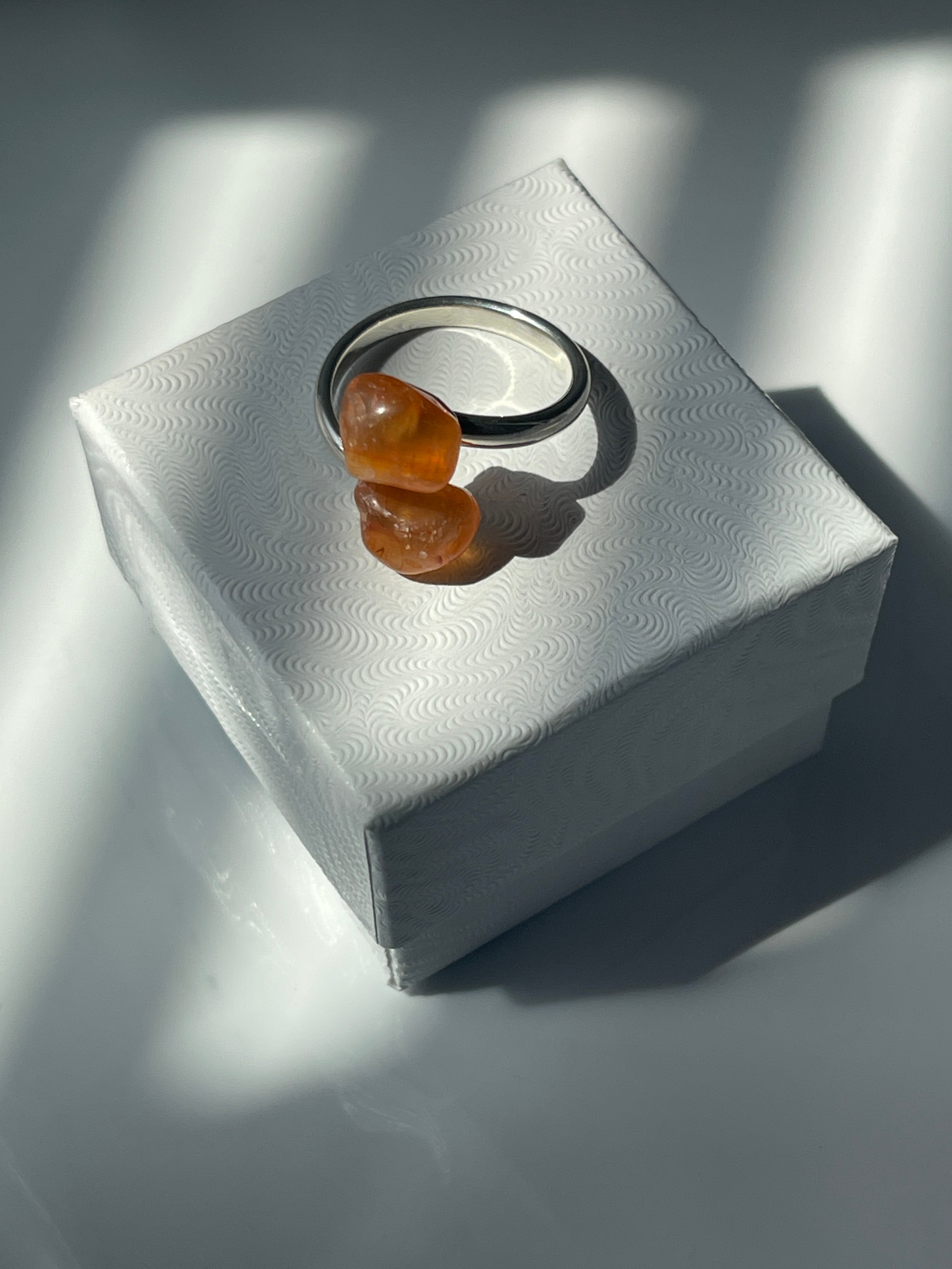 Close-up of a Carnelian Agate Ring on top of a white jewelry box in Florida 
