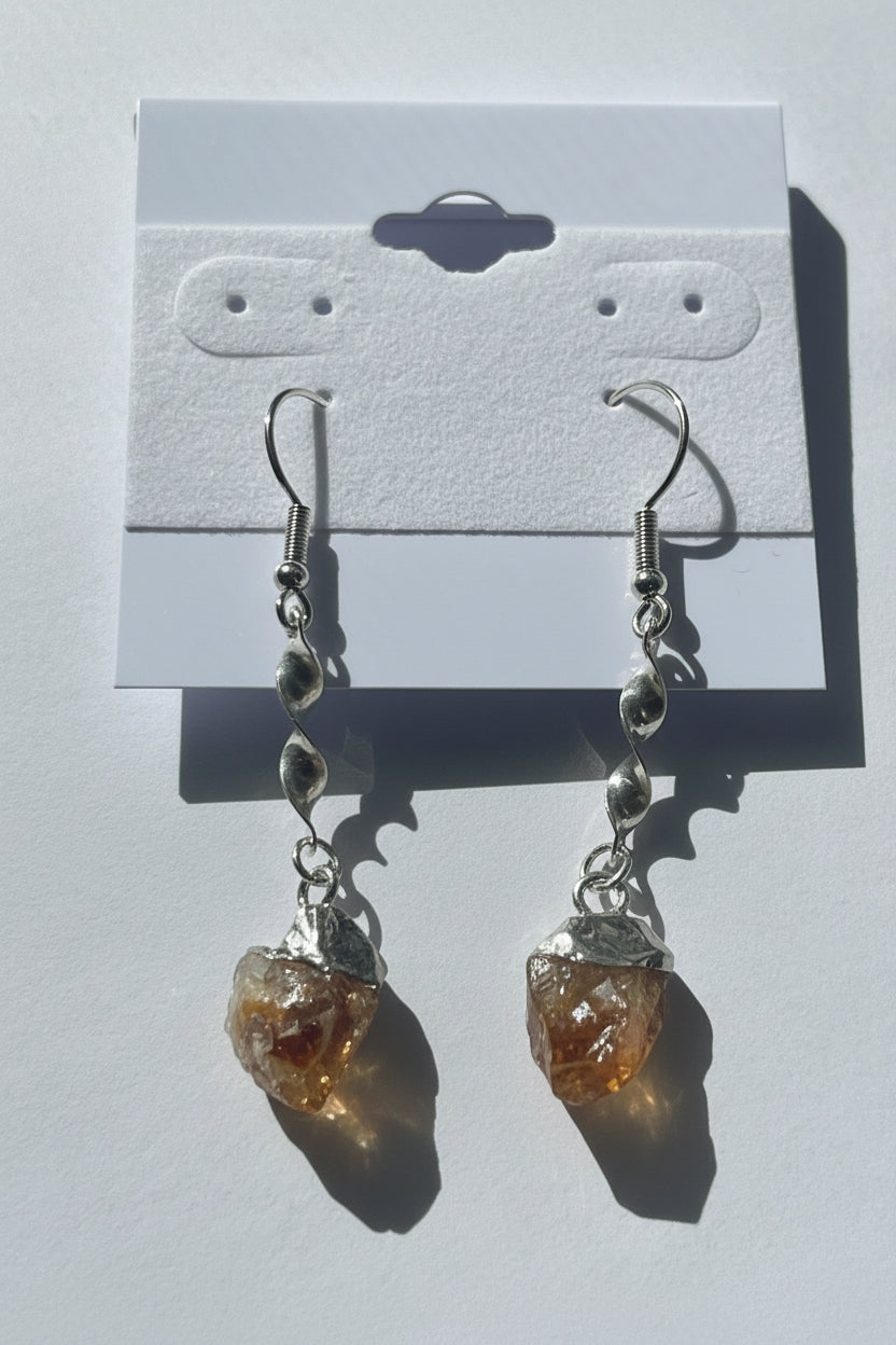 Pair of earrings with citrine stones on a gray background