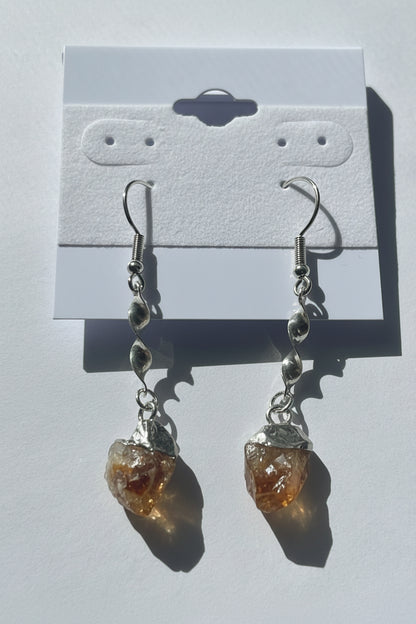 Pair of earrings with citrine stones on a gray background