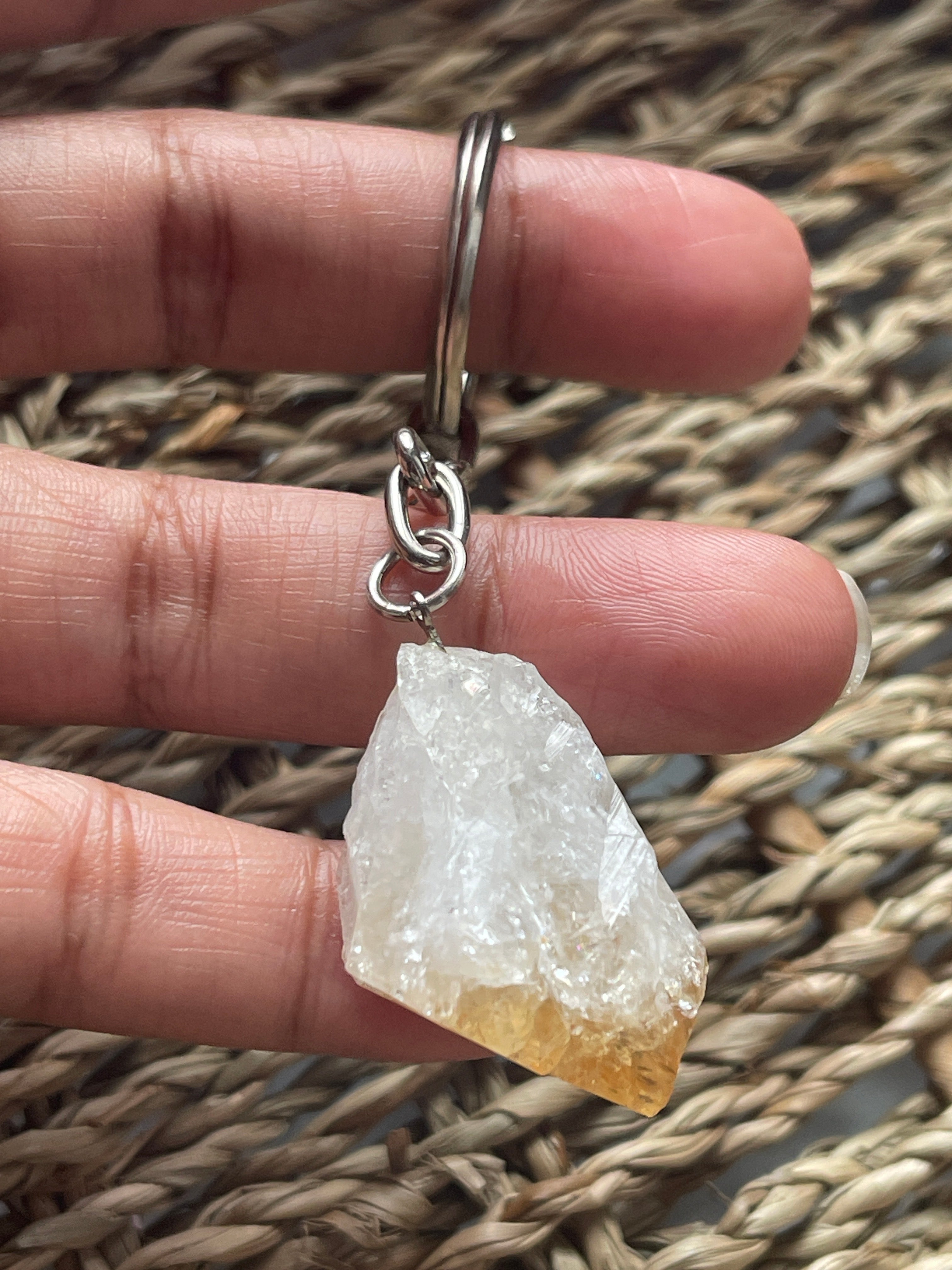 Citrine Point Keychain at Pure Energy Crystals in Florida  Keychain on a chain held between fingers against a woven backdrop