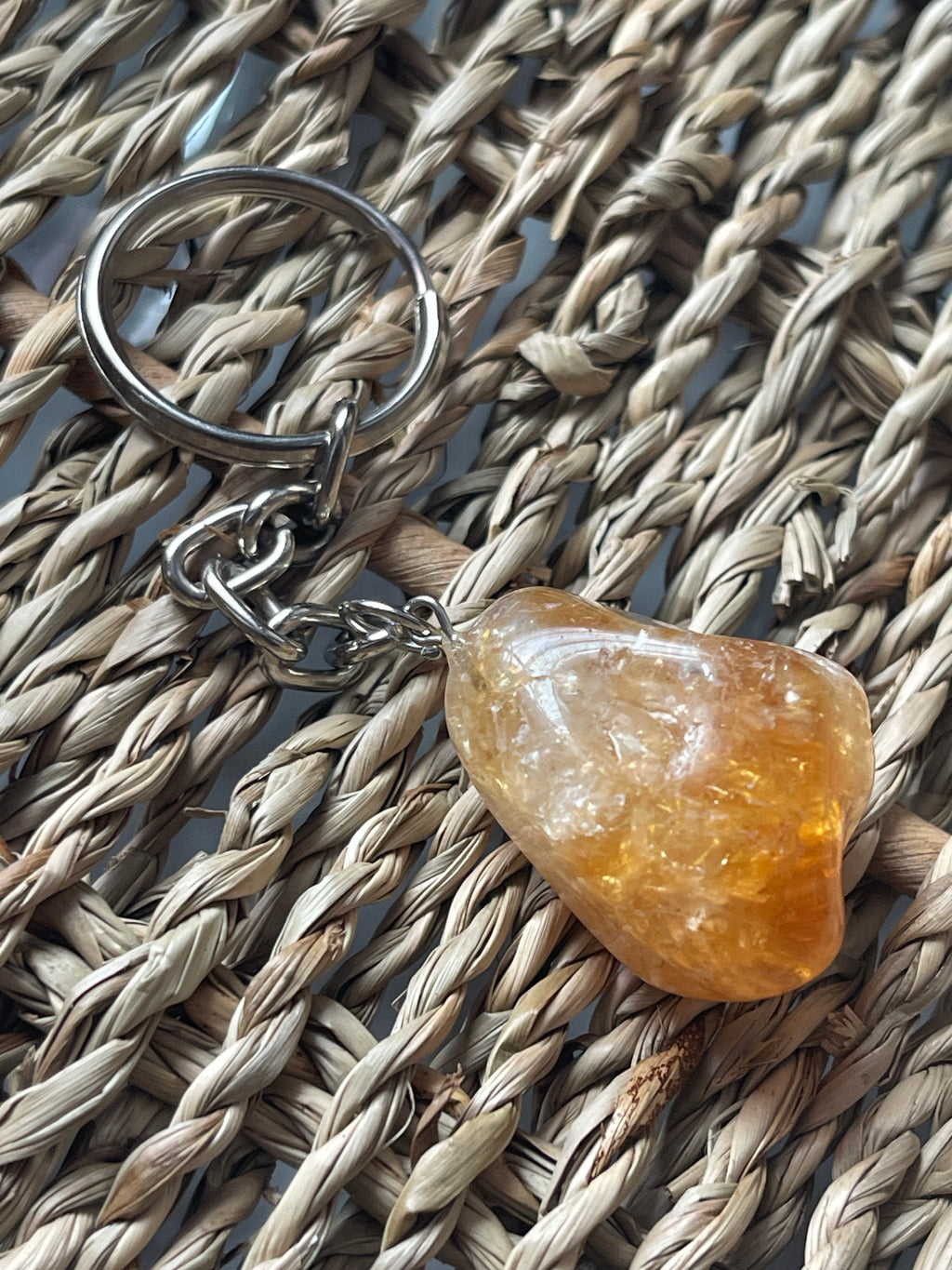 Citrine Keychain with a orange stone on a woven surface