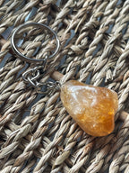 Citrine Keychain with a orange stone on a woven surface