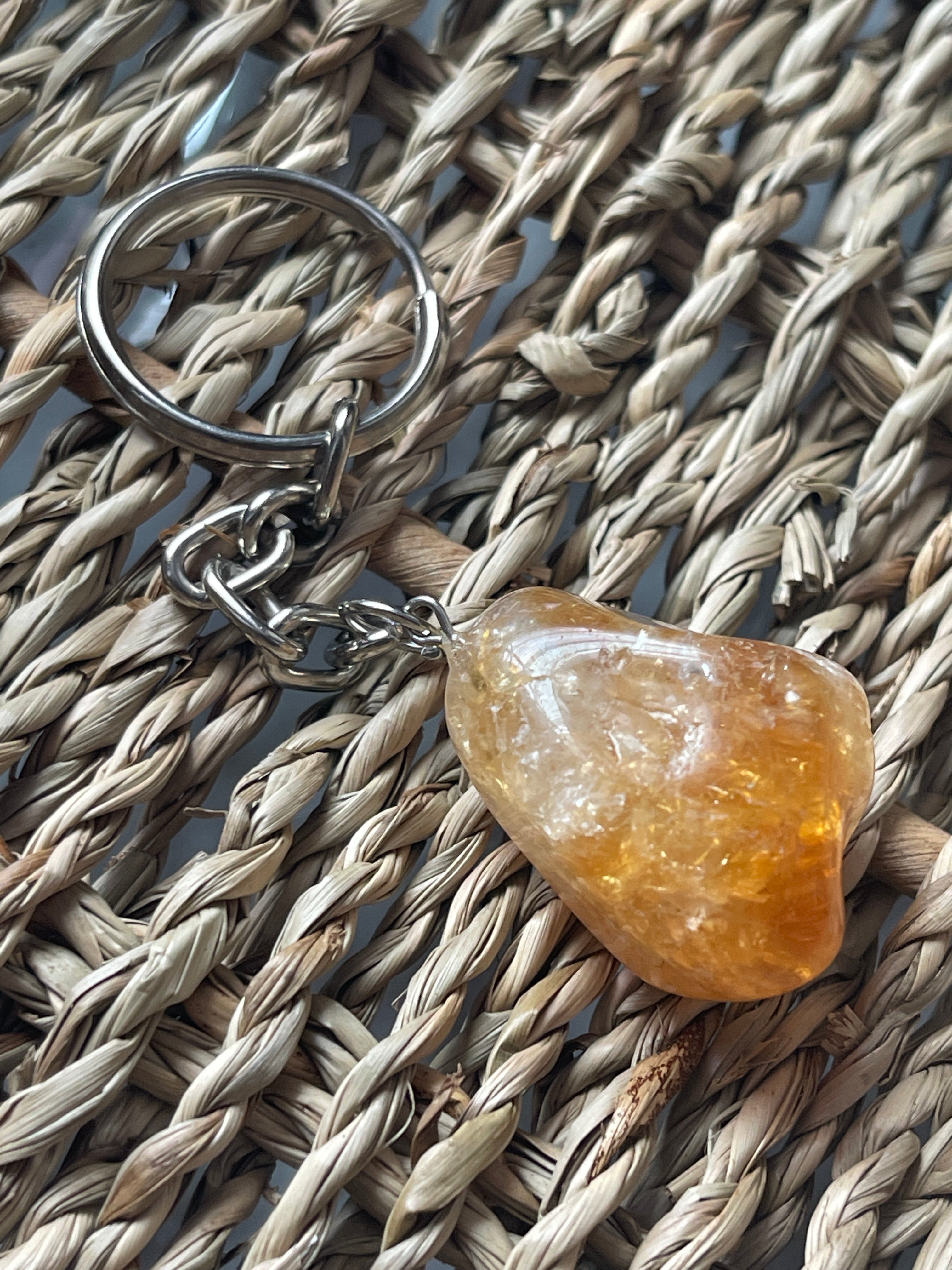 Citrine Keychain with a orange stone on a woven surface