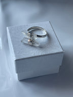 Silver Clear Quartz ring with a clear gemstone in a textured white jewelry box on a matching white background