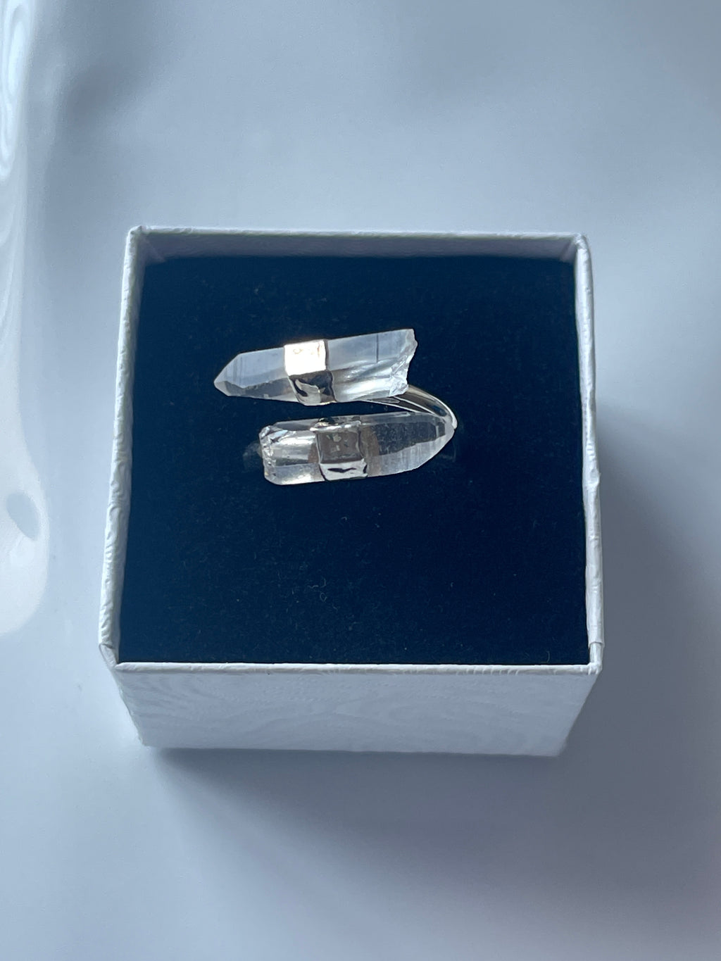 Clear quartz silver plated ring in a jewelry box on a white background 