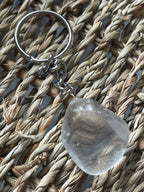 Clear stone with a keychain on a woven surface