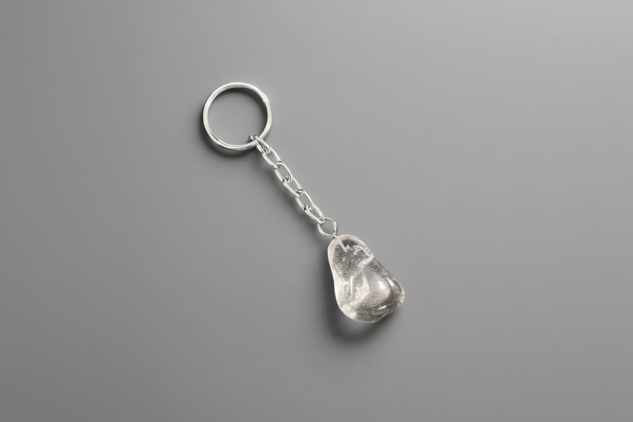 A polished keychain featuring a clear quartz crystal attached to a metal keyring.