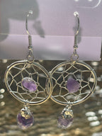 Dream Catcher Earrings, Silver dreamcatcher earrings with purple stones on a blurred background