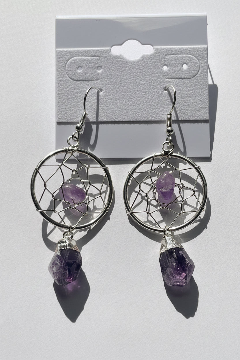Dreamcatcher earrings with amethyst stones on a light background