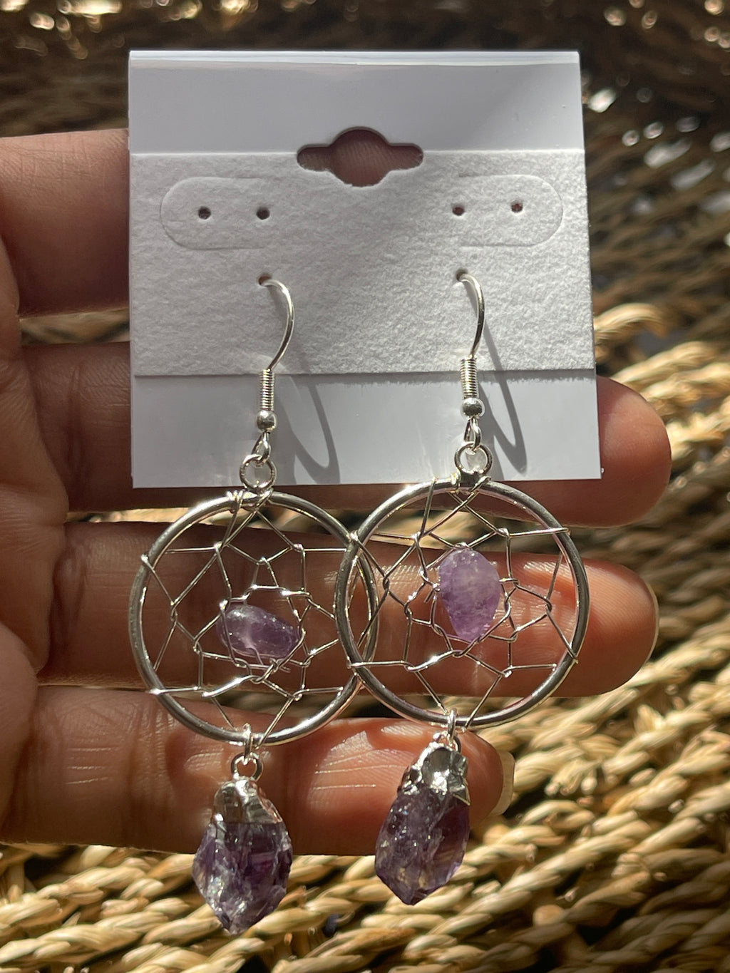 Dream Catcher Earrings, Dreamcatcher earrings with purple stones held against a textured background